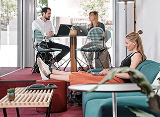 Megatrend New Work - Wie er sich auf die Büroeinrichtung auswirkt Mitarbeitende arbeiten in New Work-Arbeitswelt
