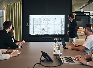 Next Level der virtuellen Zusammenarbeit Mitarbeiter von Streit Service & Solution sitzen in einem Besprechnungsraum und nutzen die Medientechnik vor Ort