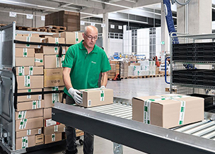 Nachhaltiger Lieferrhythmus von Bürobedarf Mitarbeiter von Streit Service & Solution verladet Pakete im Logistikzentrum in Gengenbach