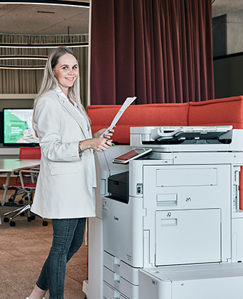 Bürotechnik im STREIT Shop Mitarbeiterin von Streit Serivce & Solution steht am Drucker und hält ein Ausdruck in der Hand